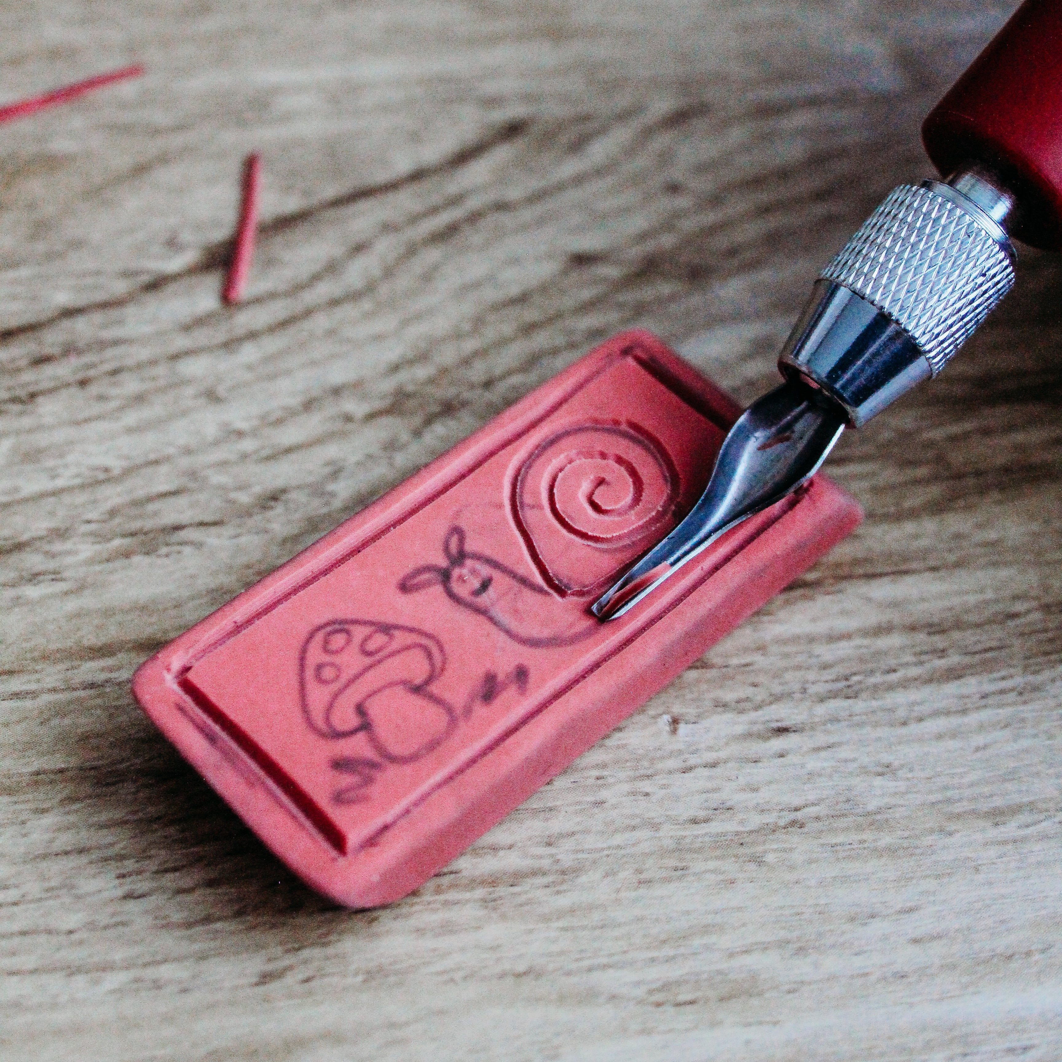 An eraser is being carved with a linoleum cutting tool.
