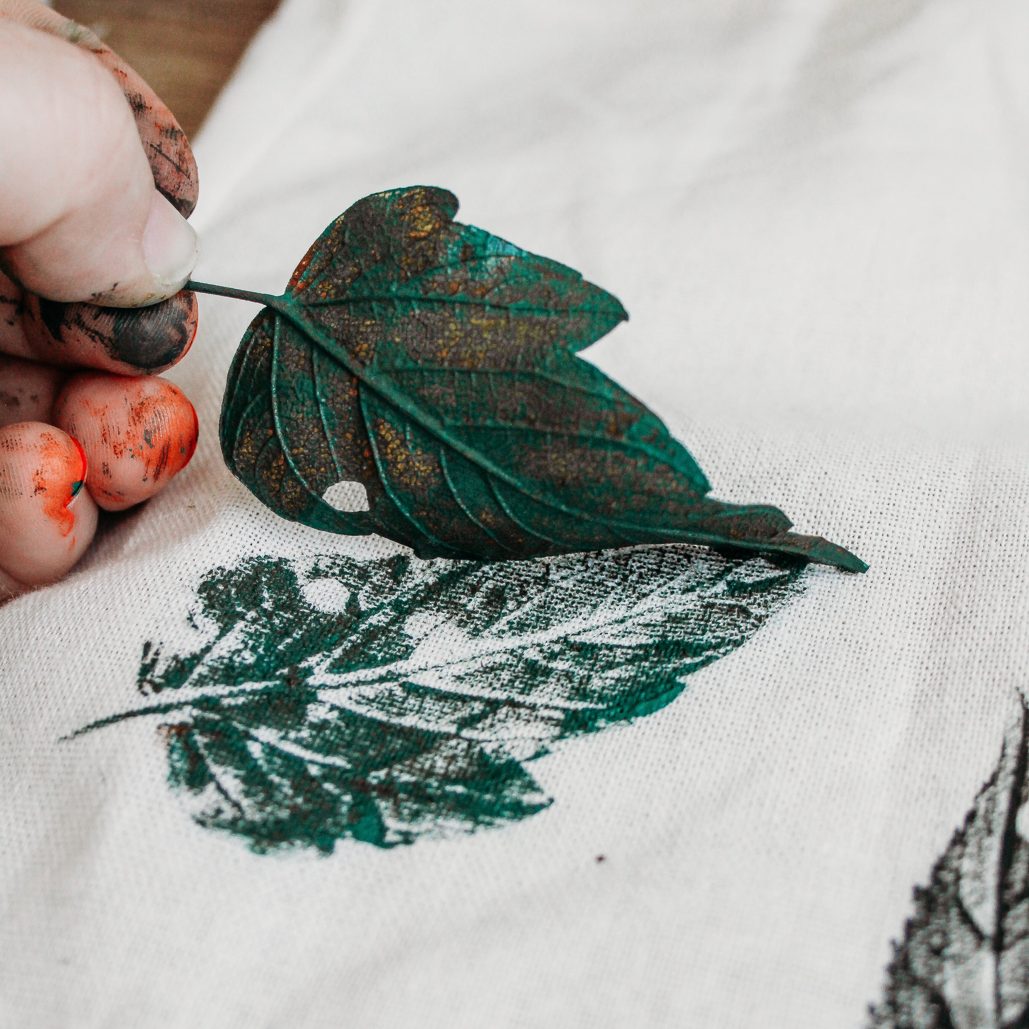 A printed leaf is being lifted from a canvas bag.