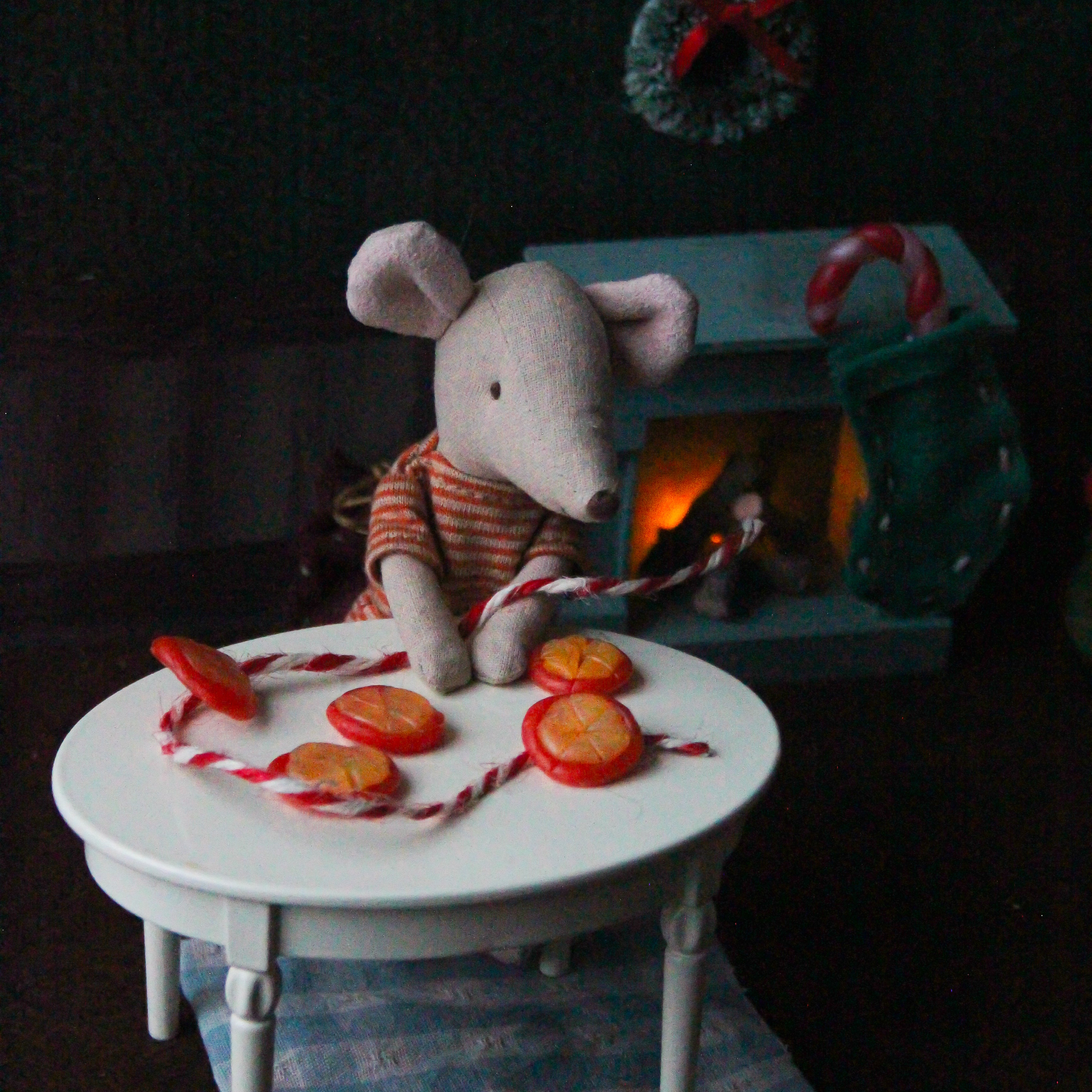 A Maileg mouse sits crafting with oranges.