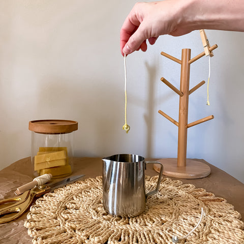 hand holding a cotton candle wick dipped in beeswax