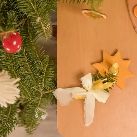 three hand dipped beeswax candles wrapped with chiffon ribbon and a sprig of fir 