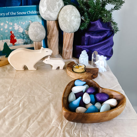 mix of loose parts in a heart shaped wooden bowl on winter nature table