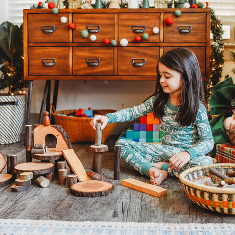 A child plays with a peg doll at stacked up Eco Blocks.