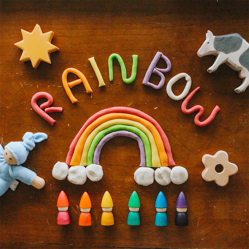 Rainbow play dough next to rainbow tomten dolls