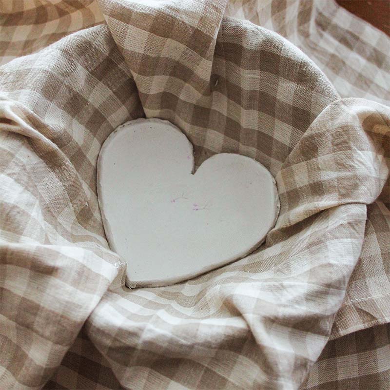 An air dry clay heart sits in a bowl.