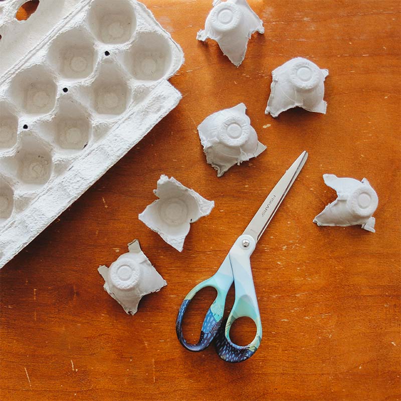 A cut up egg carton sits on a table.