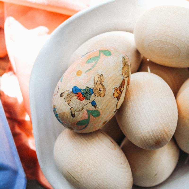 A Peter Rabbit Wooden Easter Egg sits in a White ceramic Windrow dish.