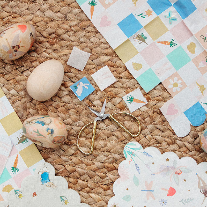 Napkins are being cut for a wooden egg craft for easter.