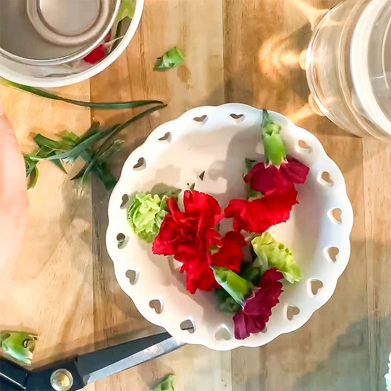 A bowl of fresh flowers sit on a table.