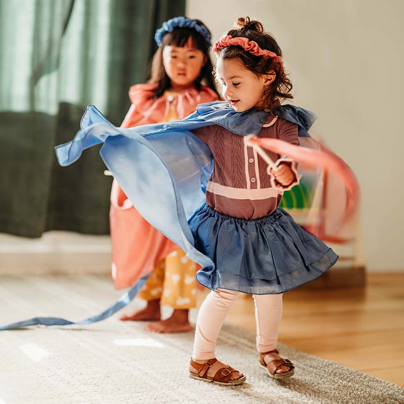 Two girls are playing with playsilks