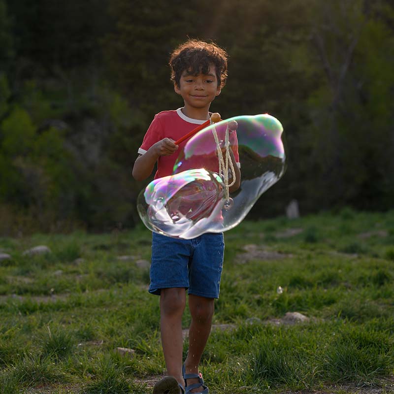 kid playing with giant bubbles at recess