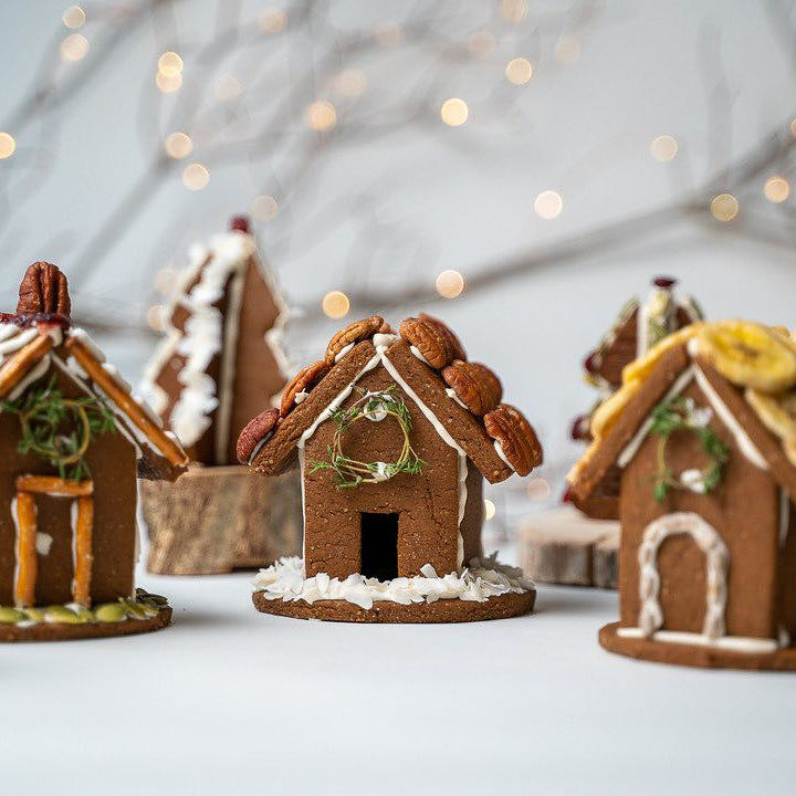 A sugar free gingerbread house sits on a white tabletop.