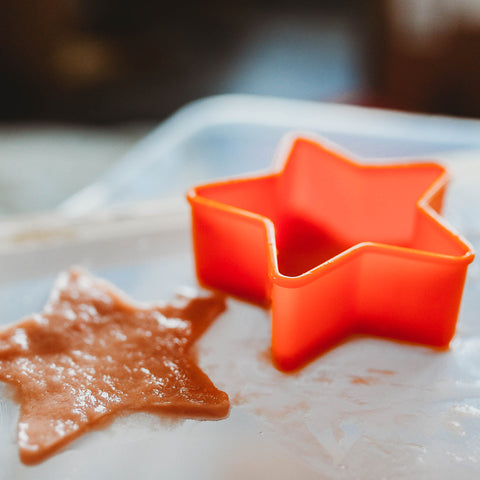 Cookie cutter being used to create star shaped paper.
