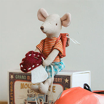 A mouse sits embroidering a small classic mushroom.