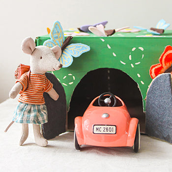 A Maileg Mouse stands next to a Maileg Mouse Car in a butterfly car garage.