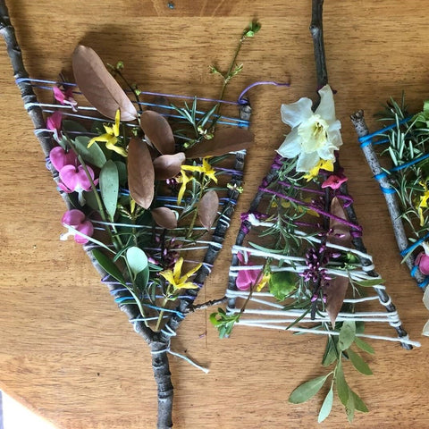 Nature weavings made out of sticks, twine, and nature finds like flowers, leaves, etc.