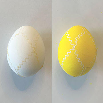 Two eggs with beeswax designs on them. One has been dyed yellow | Bella Luna Toys