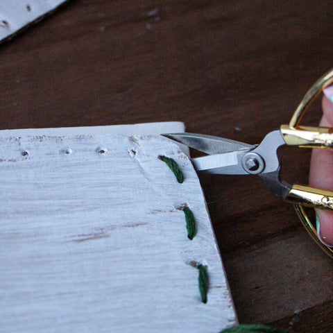 Gold scissors is cutting paper.