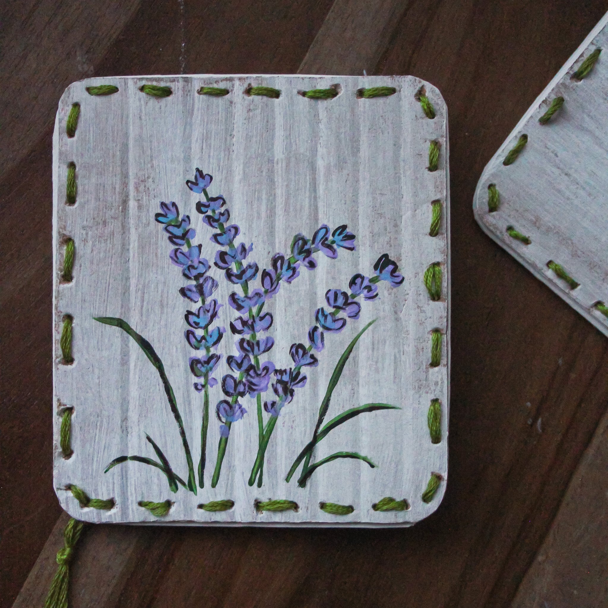 A Bella Luna upcycled card with lavender painted on it sits on a table.