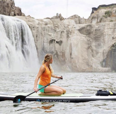 girl paddleboarding on lake