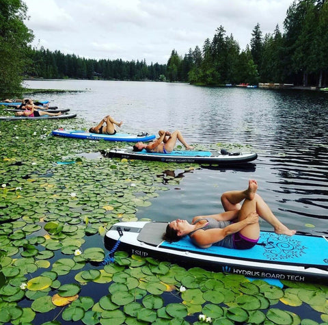 people doing yoga on paddleboards