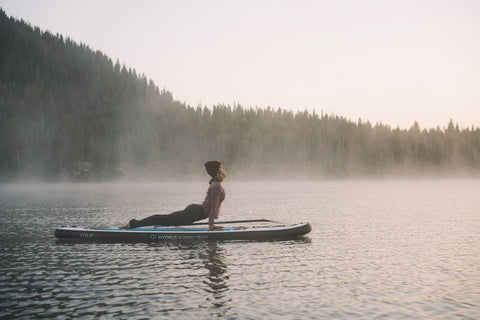 girl on paddleboard doing yoga