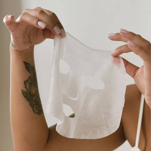woman holding a sheet mask