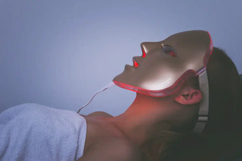 Woman lies down while wearing a red LED light therapy mask