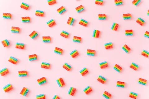 Colorful sour candy on pink background