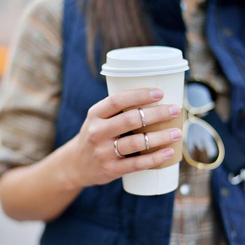 woman holding travel mug with coffee take care of your skin and skip in flight