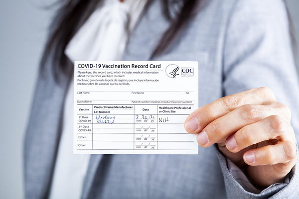 Woman holding Covid 19 Vaccine card