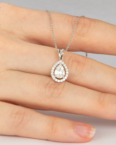 pear diamond necklace being held. centre pear diamond surrounded by diamond halo on a platinum chain.