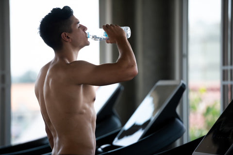 Man drinking sugar free energy drink while doing a treadmill workout