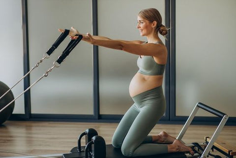 ic:Pregnant mom doing reformer Pilates