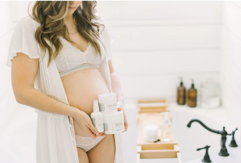 pregnant mom holding stretch mark cream