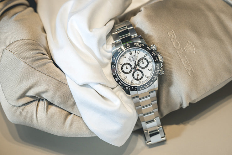 a person wearing a glove holding a rolex