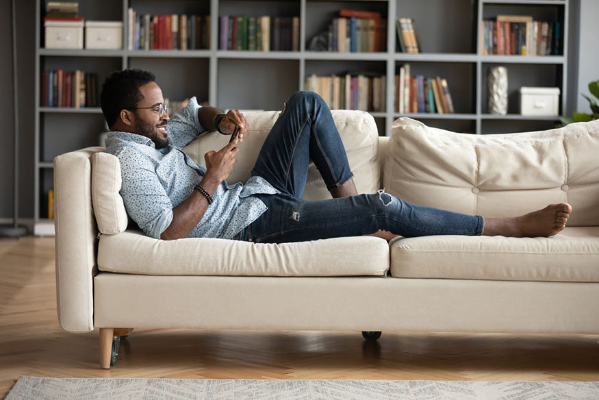 man lounging on couch with phone