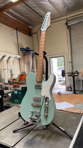 Photograph of a Jennings Guitars 'Navigator' handmade telecaster style electric guitar. Styled in a Cabronita variant with filtertron pickups, a vibrato, roasted maple fingerboard and finished in a unique new colour by Jennings called 'Satin Fern' Green.