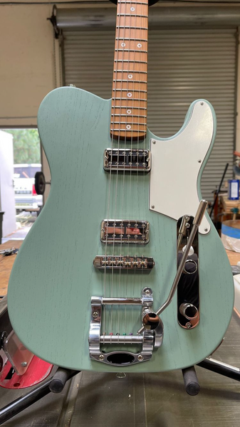 Photograph of a Jennings Guitars 'Navigator' handmade telecaster style electric guitar. Styled in a Cabronita variant with filtertron pickups, a vibrato, roasted maple fingerboard and finished in a unique new colour by Jennings called 'Satin Fern' Green.