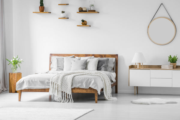 Comfortable wooden bed in a bright bedroom ensures optimal sleep when paired with a clutter-free sleep environment and consistent bedtime routine