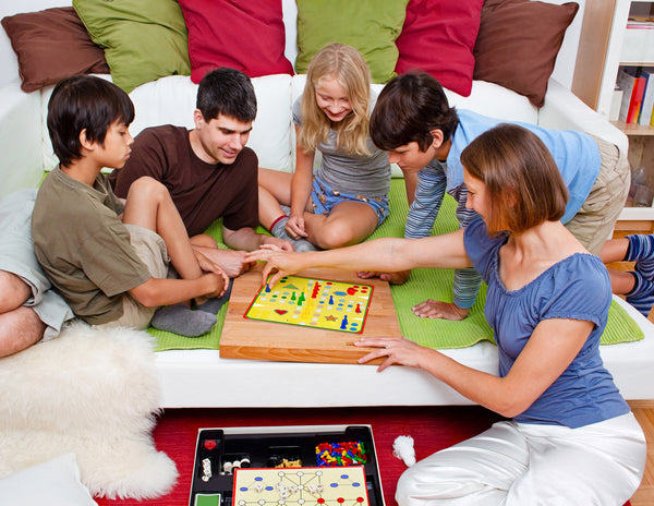 family-game-night-on-a-giant-12-foot-Family-Bed-by-Taylor-&-Wells-big-mattress-sleep-training-infant-care-risk-factors