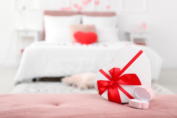 Gift box with an engagement ring on the marital bed emphasizing the right mattress and personal touches for romance