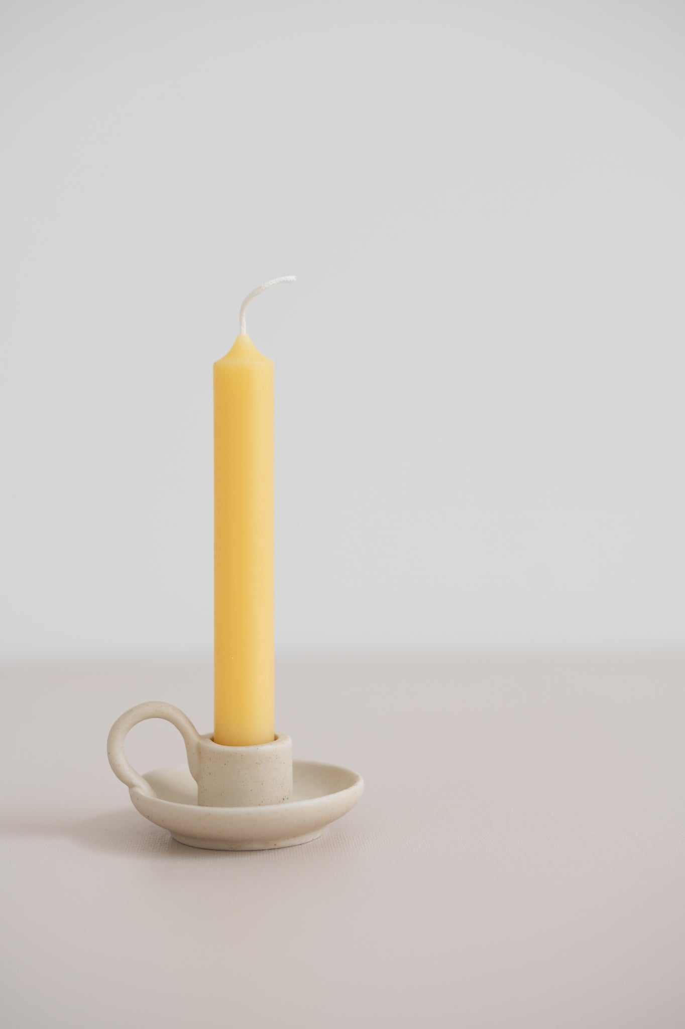 beeswax tube candle in a mini teacup candleholder