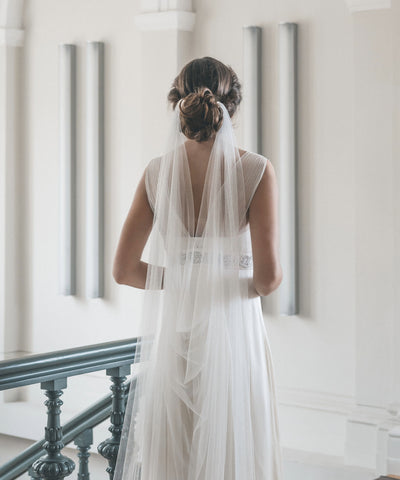 bride stand back and we see her draped veil