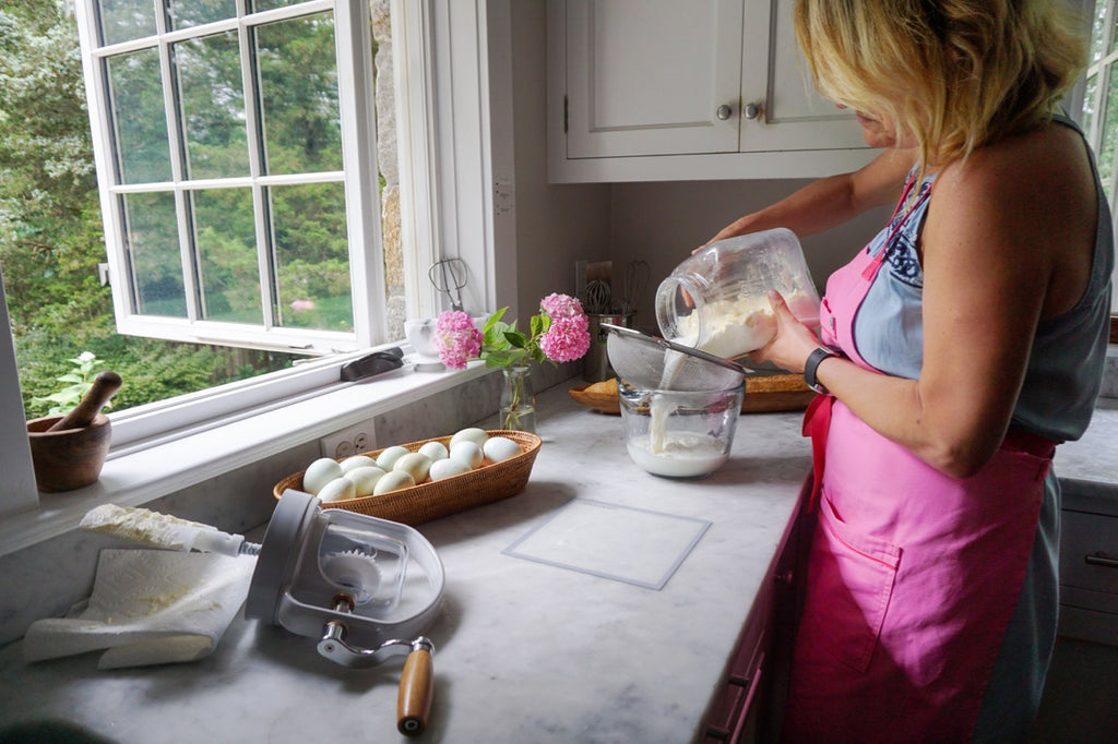 Silvia pouring buttermilk out of butter churn