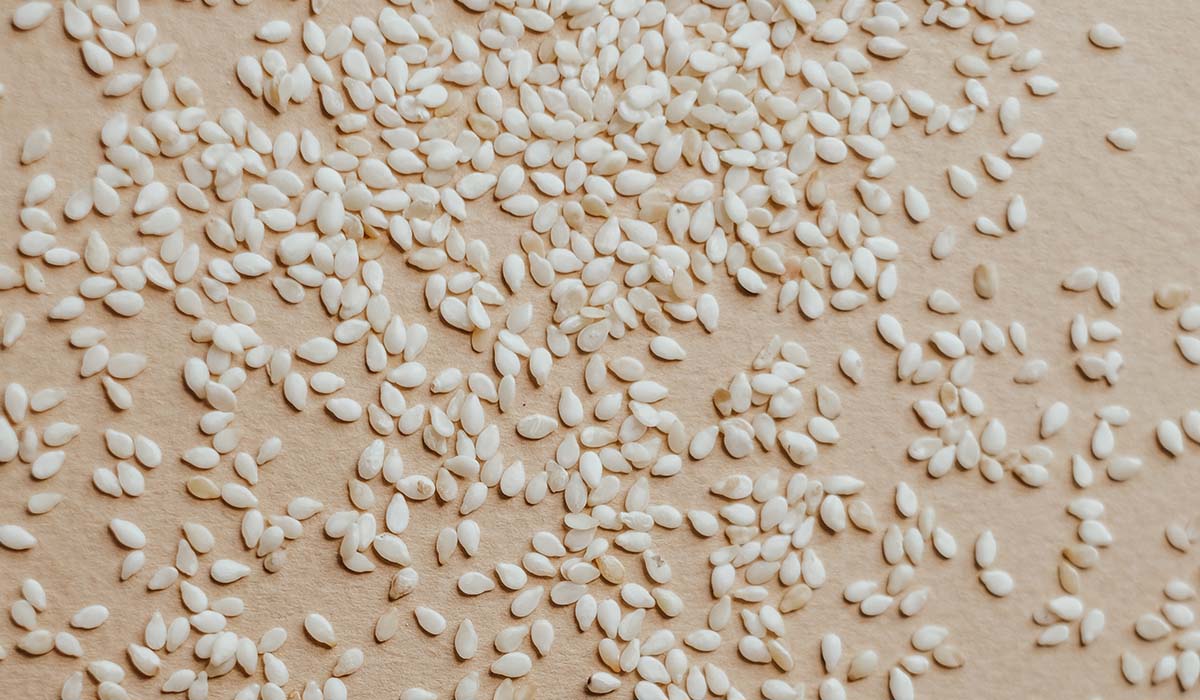 sesame seeds spread out on a tan background