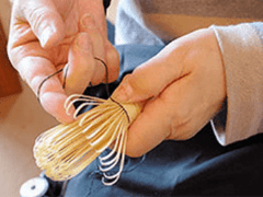 Hand weaving thread around tines of a bamboo whisk