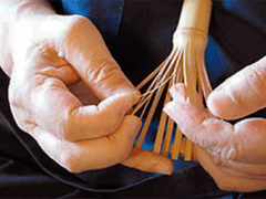 Hand pulling apart tines of a bamboo whisk
