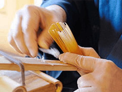 Hand carefully shaving individual tines of a bamboo whisk