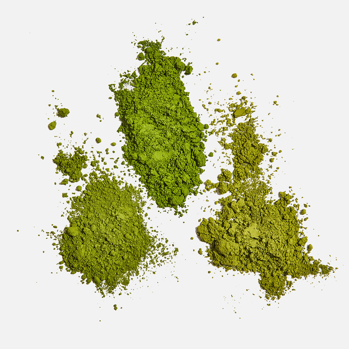 Three piles of green matcha powder